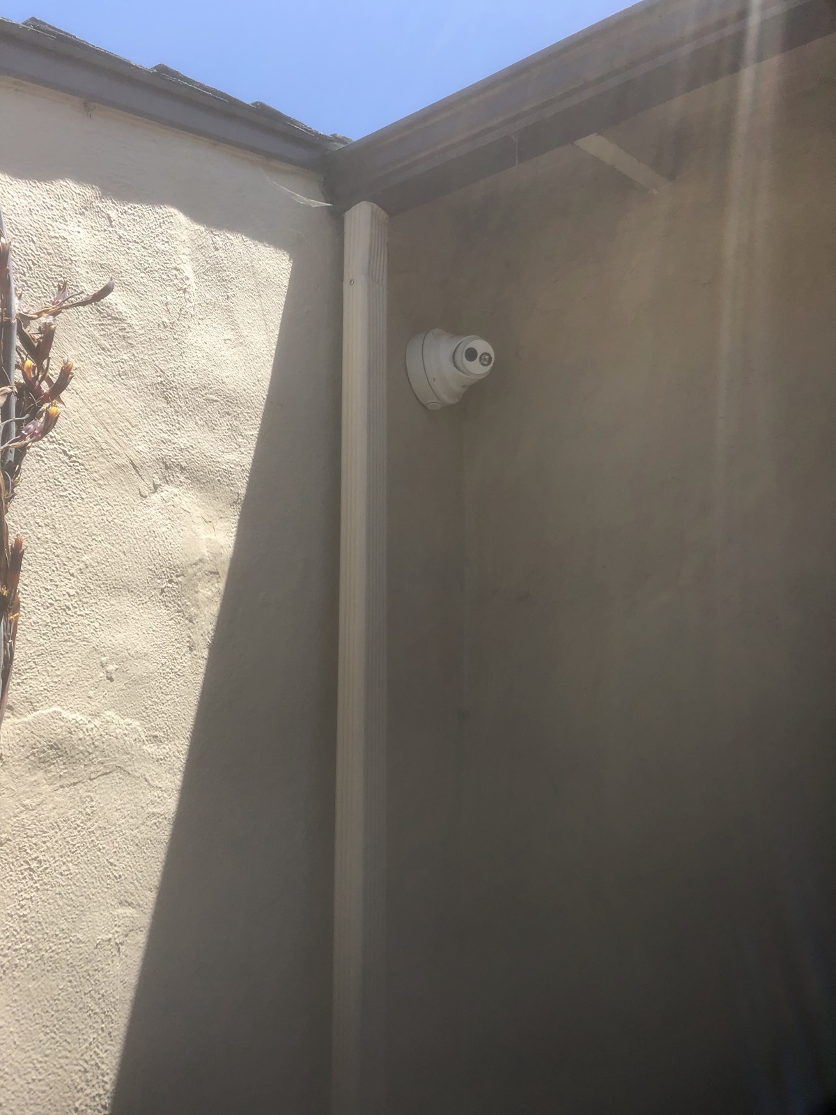 Security camera mounted beneath a building overhang